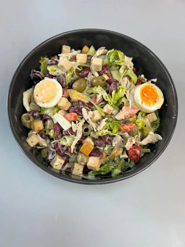 Chicken salad bowl with boiled egg and croutons