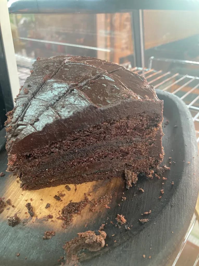 A slice of chocolate fudge cake on the counter